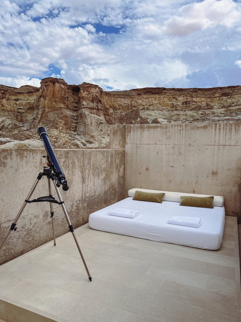 a telescope on a tripod next to a bed