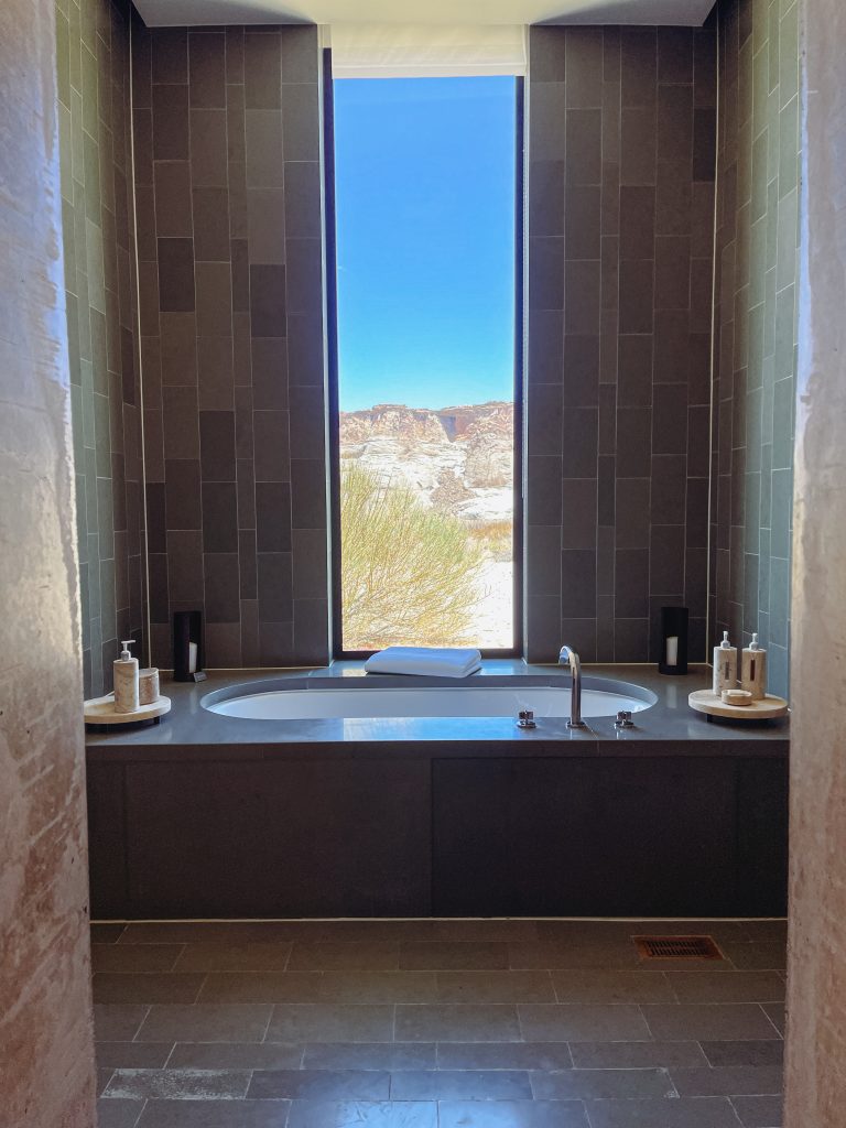 a bathtub with a window and a view of the desert