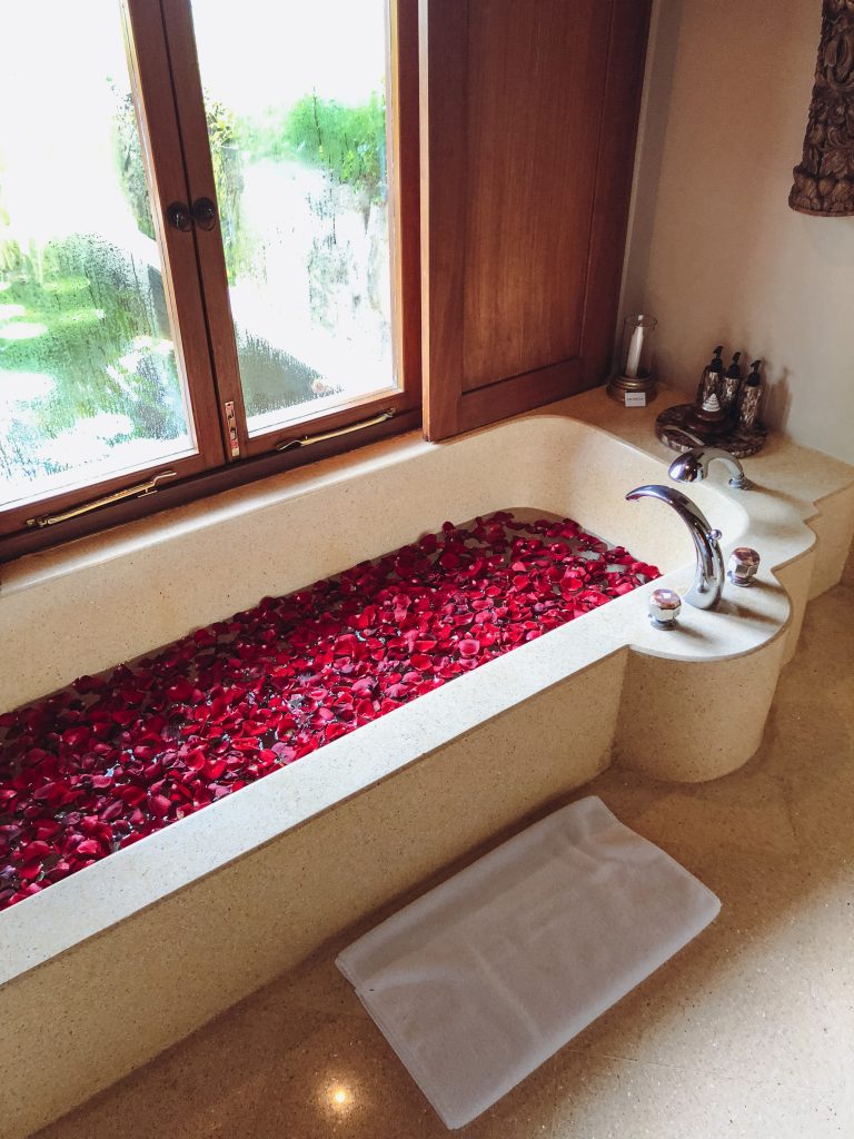 a bathtub filled with red petals