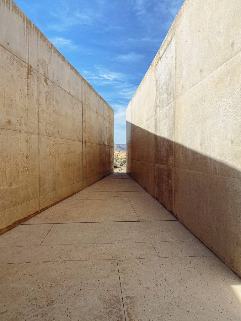 a long concrete walkway with a blue sky