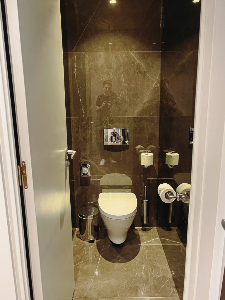 a bathroom with a toilet and a mirror