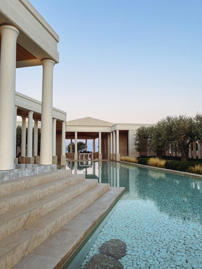 a pool with columns and a building