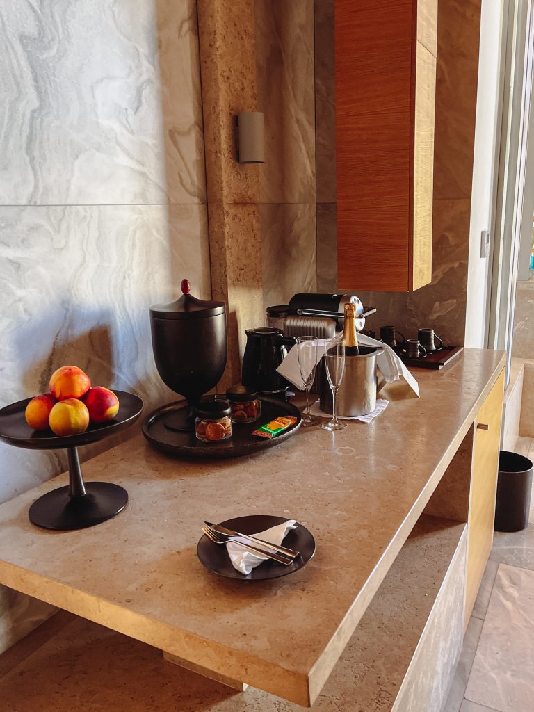 a counter with a bowl of fruit and a coffee maker