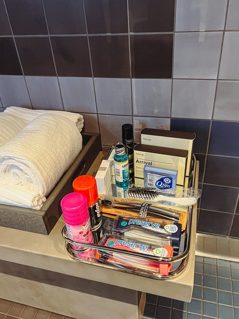 a bathroom counter with a tray of toiletries and a towel