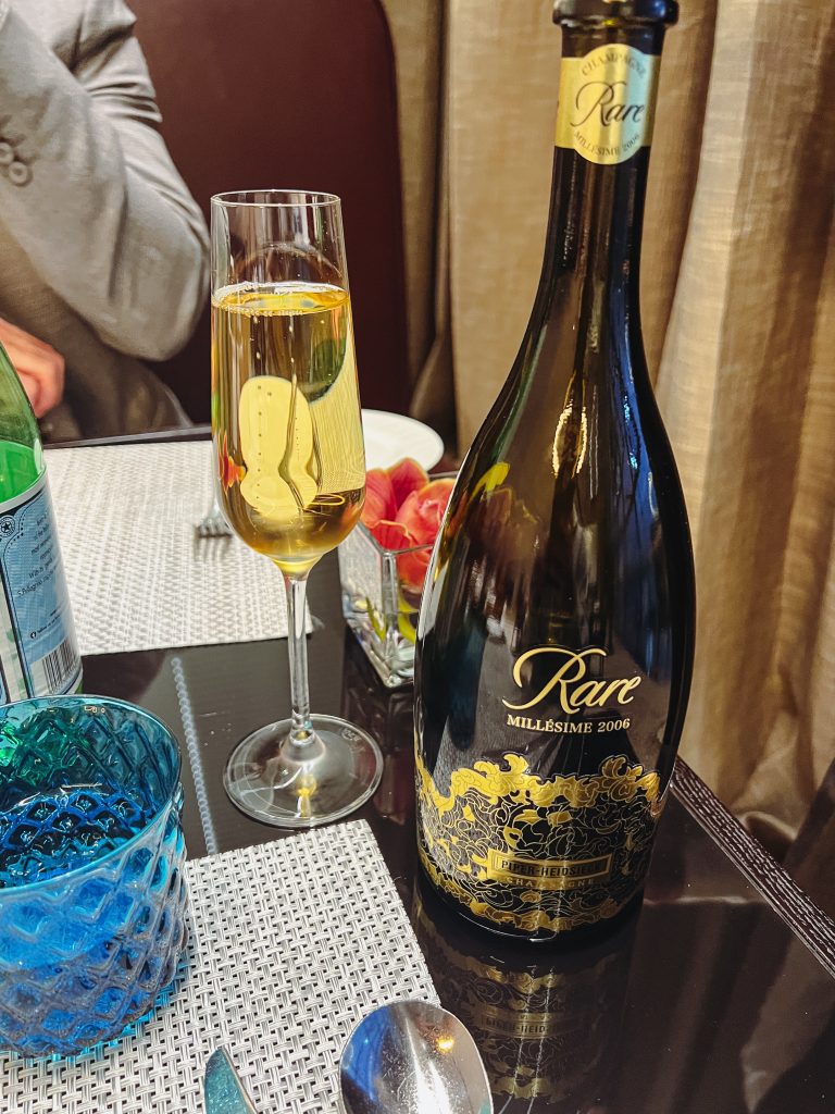 a bottle of wine next to a glass of champagne