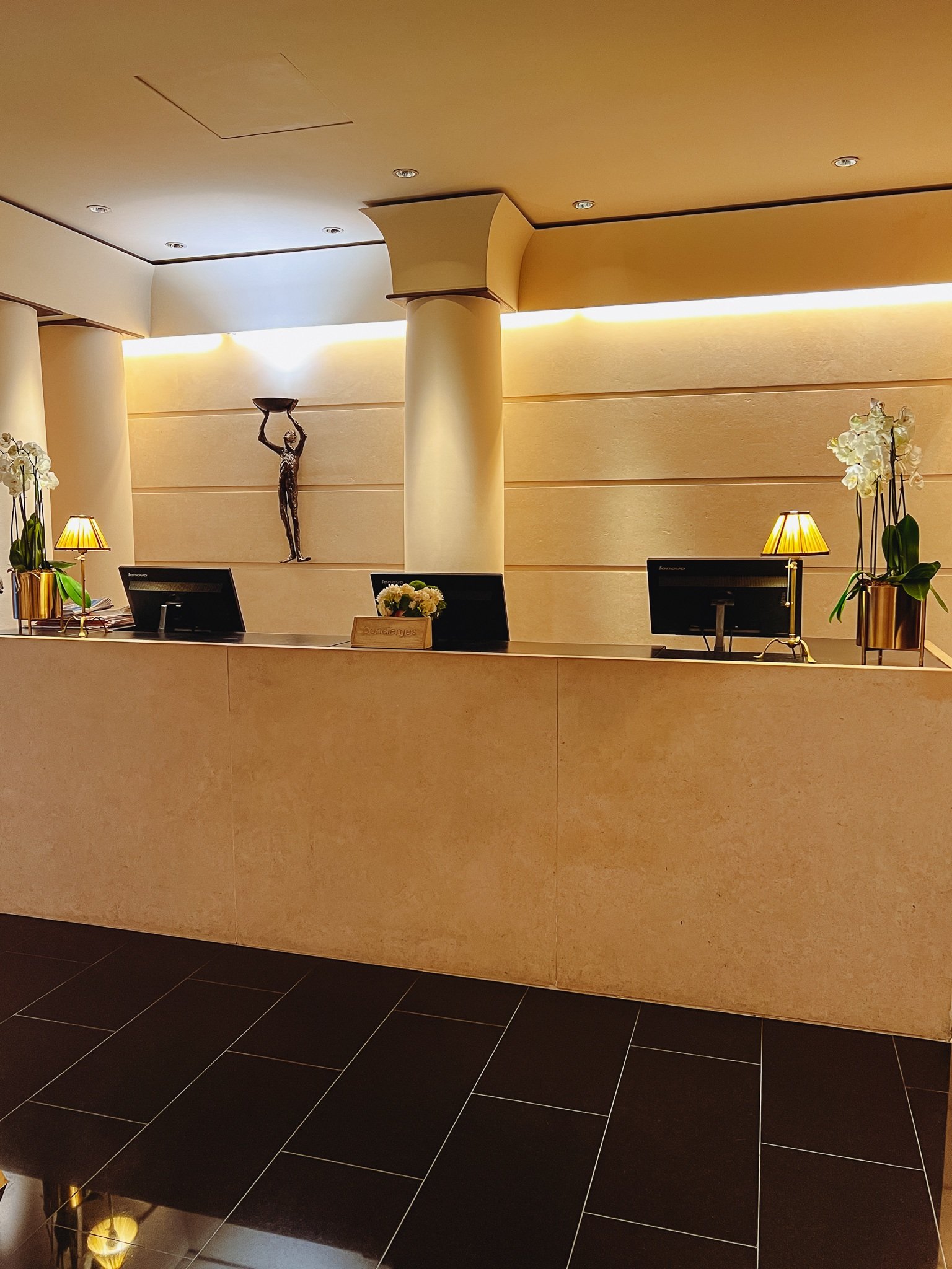 a reception desk with a statue of a woman and flowers