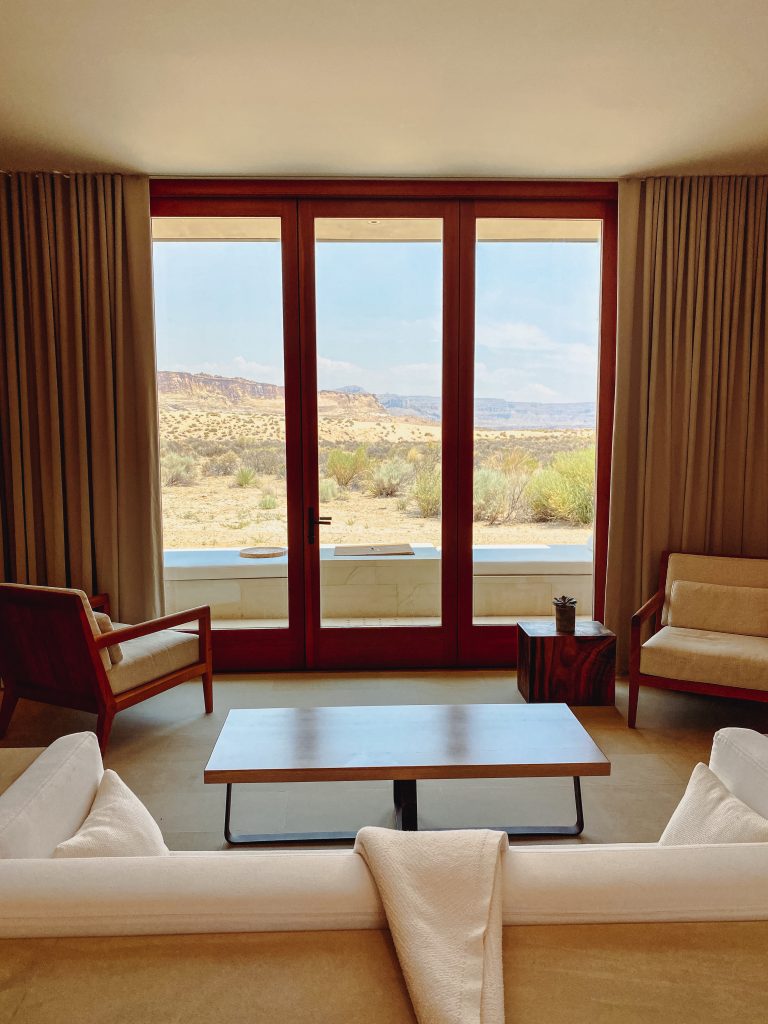 a room with a view of the desert and a couch and chairs