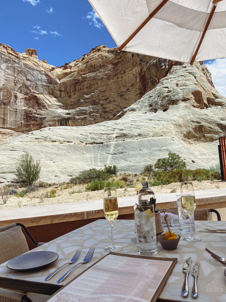 a table with glasses of wine and a mountain in the background