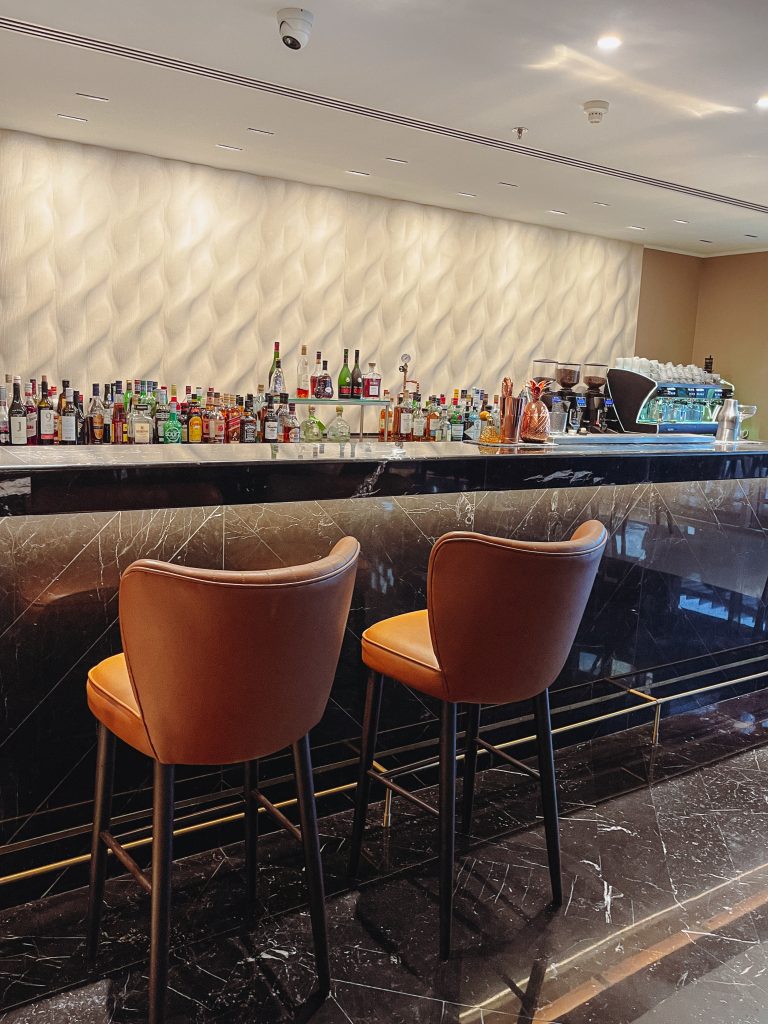 a bar with brown chairs and a black marble counter