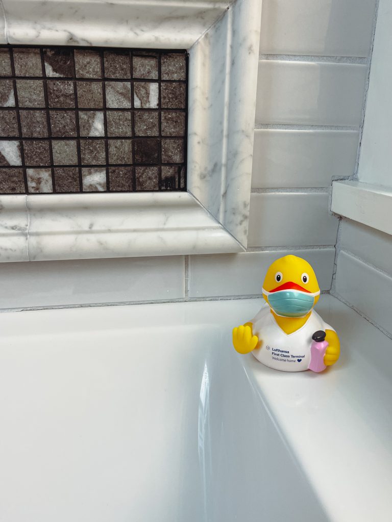 a rubber duck in a bathtub wearing a face mask