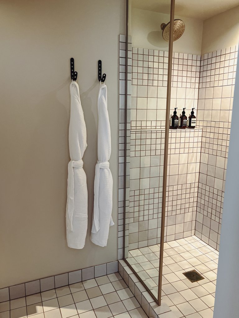 a shower with white towels on hooks