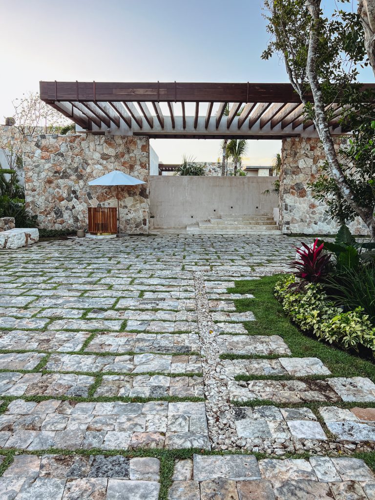 a stone patio with a pergola and a stone wall
