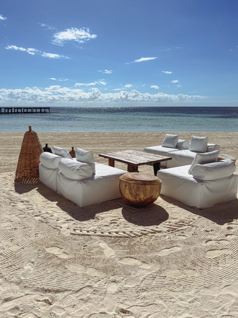 a white couches on a sandy beach
