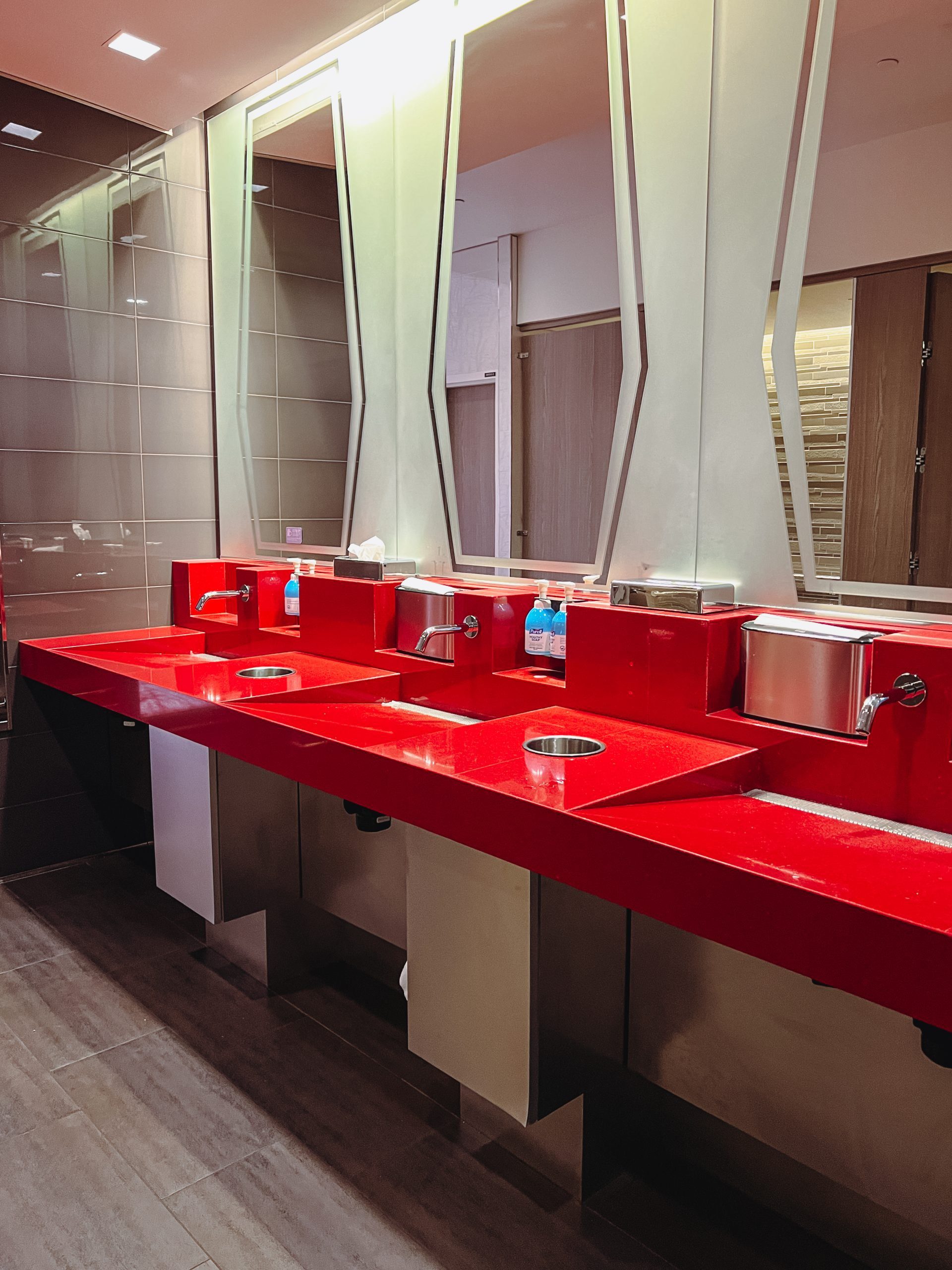 a red bathroom with sinks and mirrors