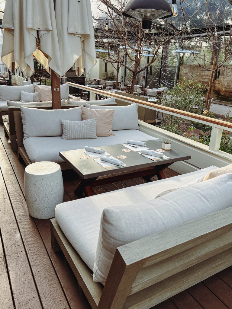 a patio with white couches and tables