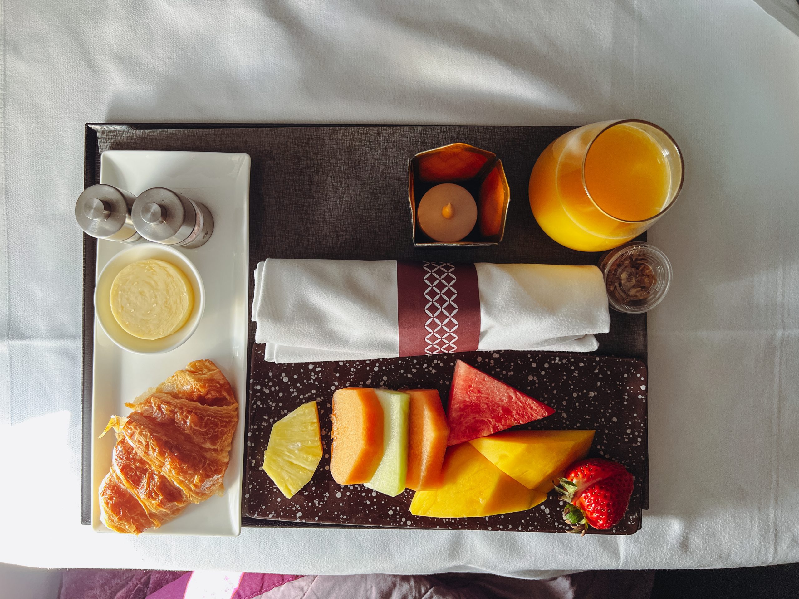 a tray of food on a bed
