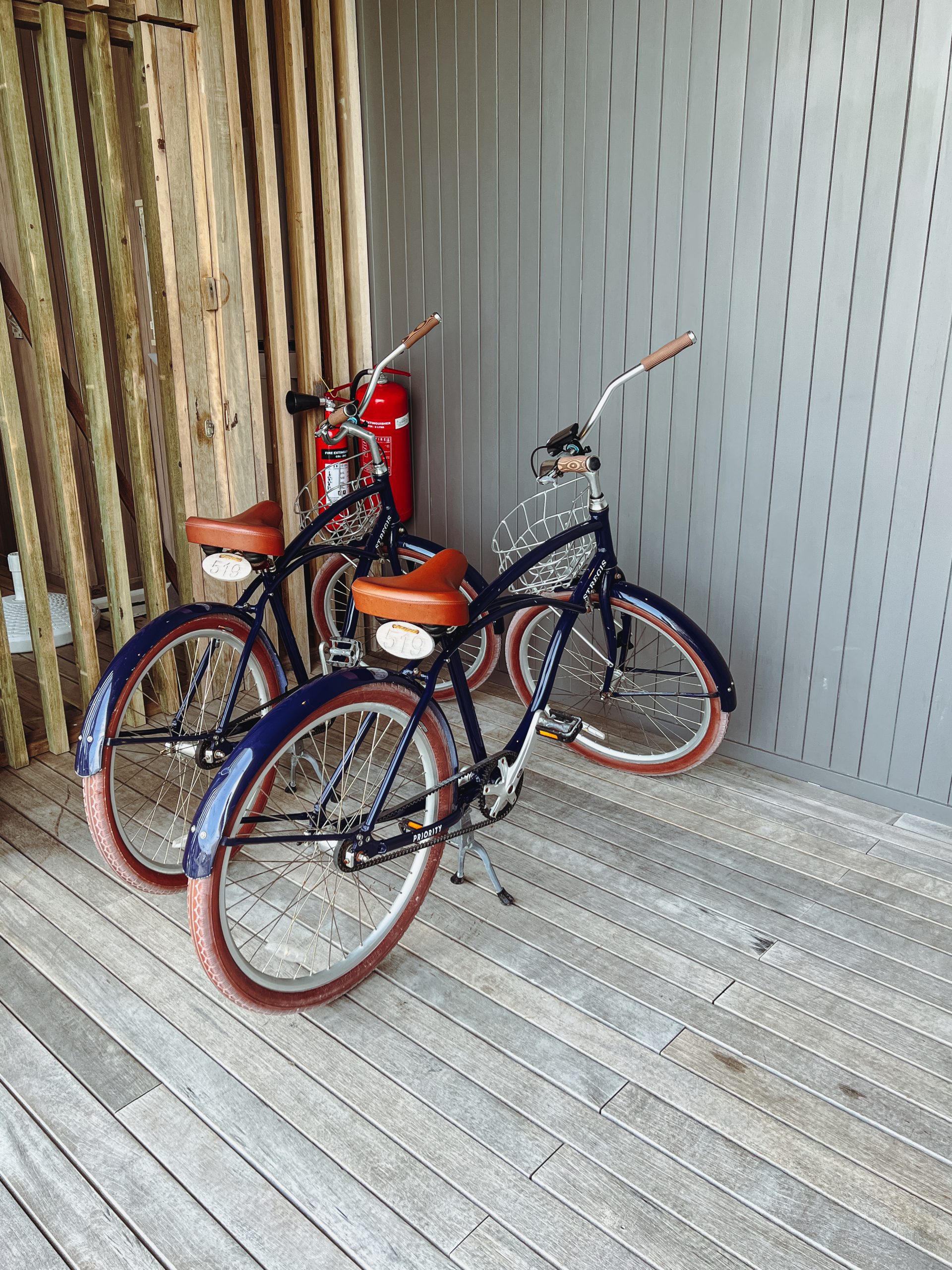 two bicycles parked next to a fire extinguisher
