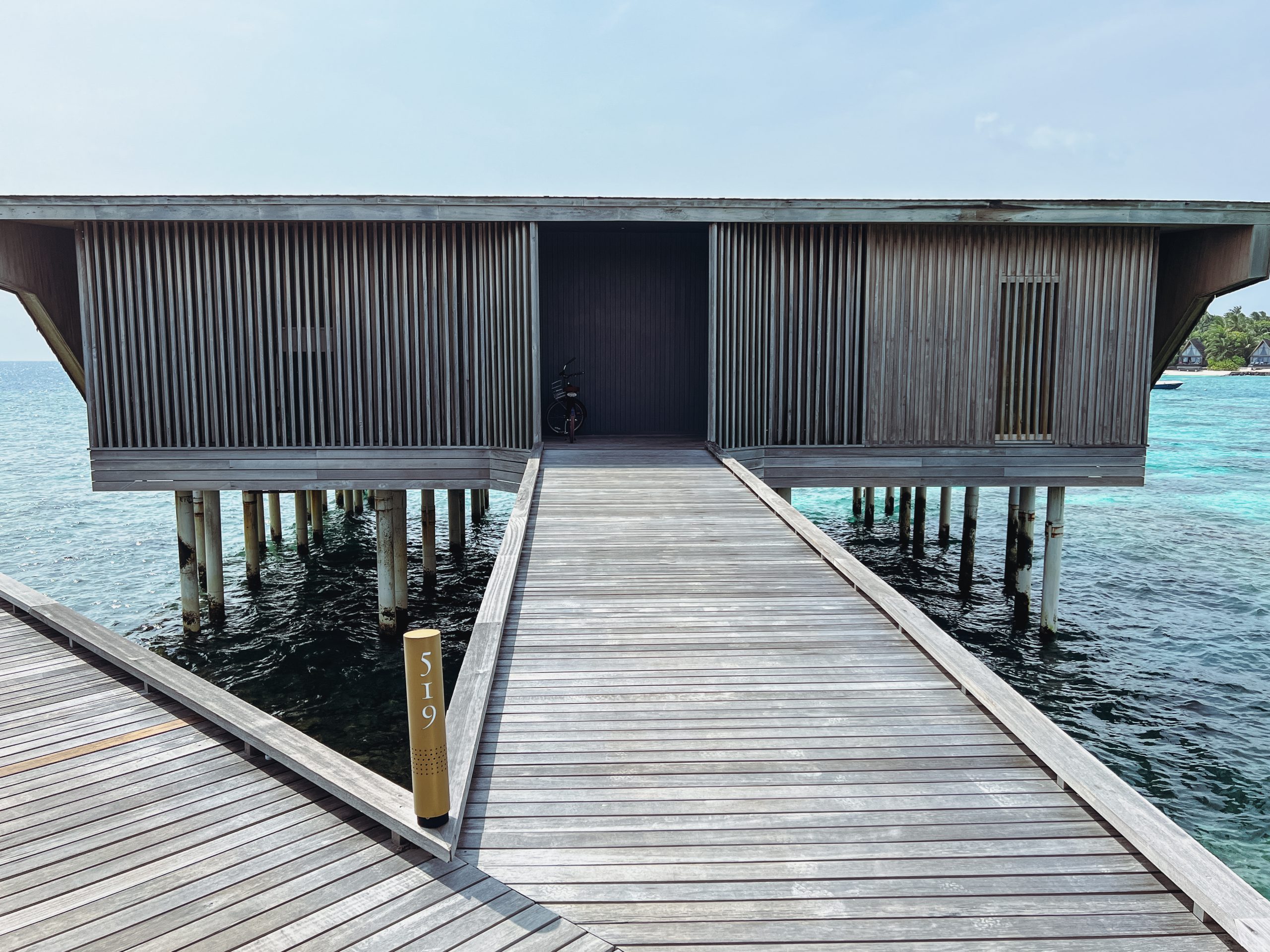 a wooden dock with a building on the water