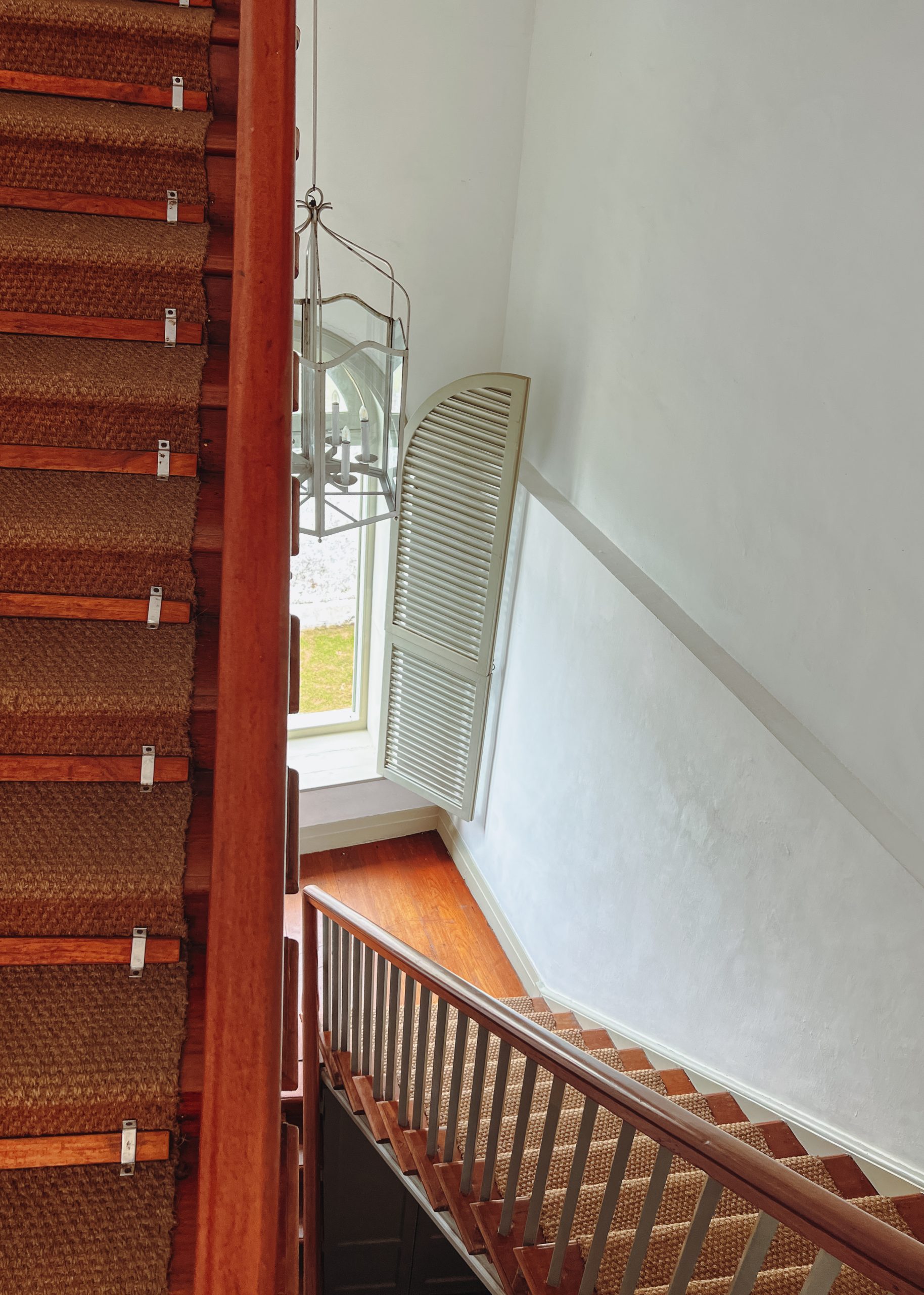a staircase with a window and carpeted staircase
