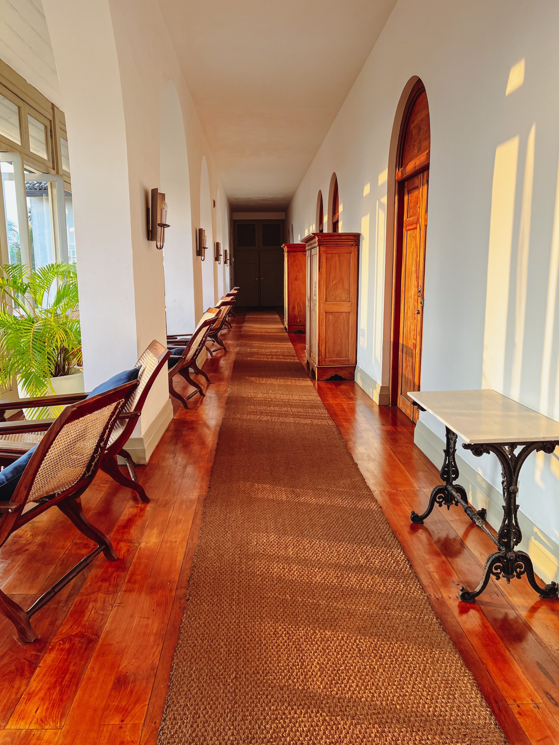 a long hallway with chairs and a table