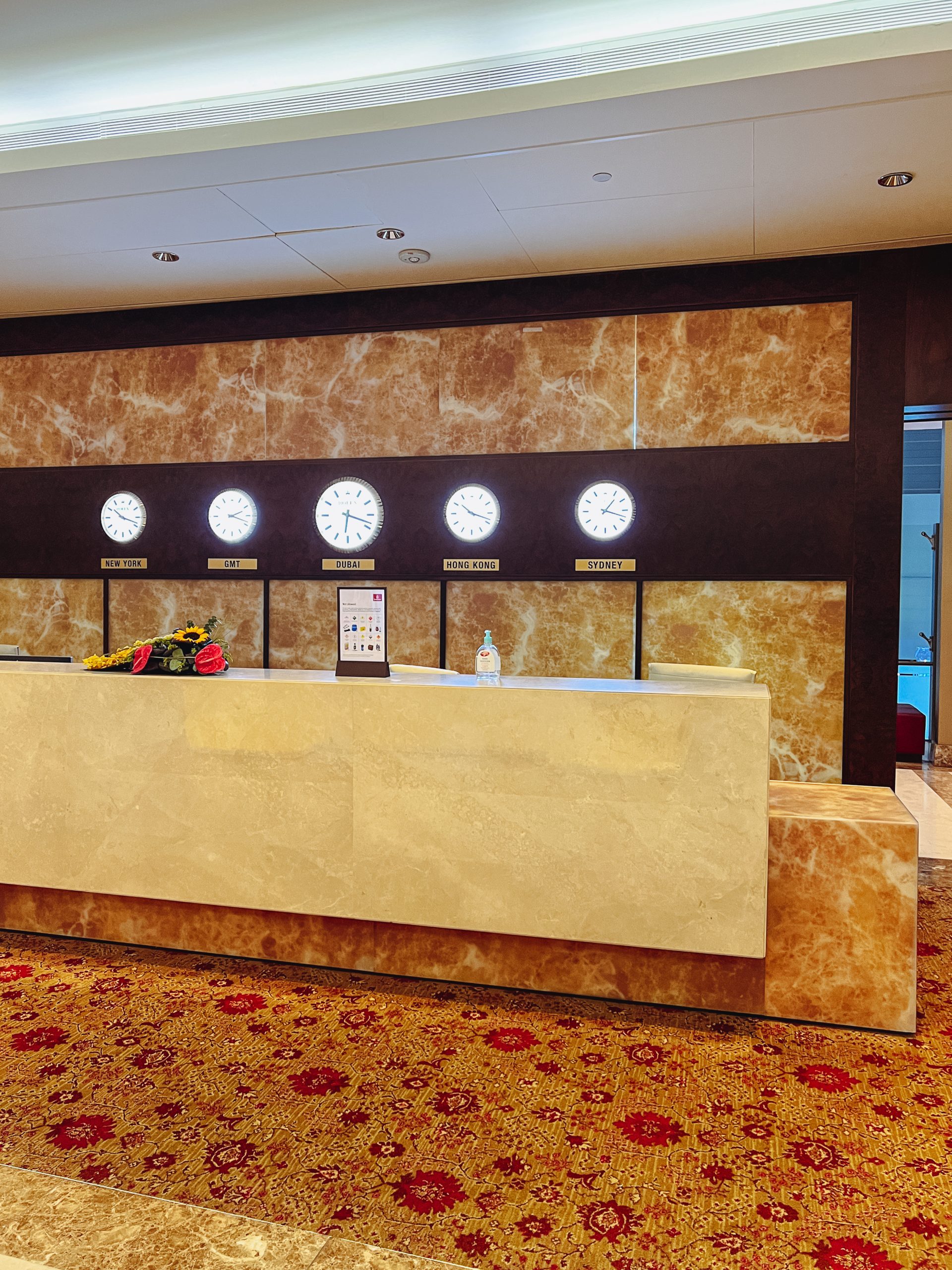 a reception desk with clocks on it