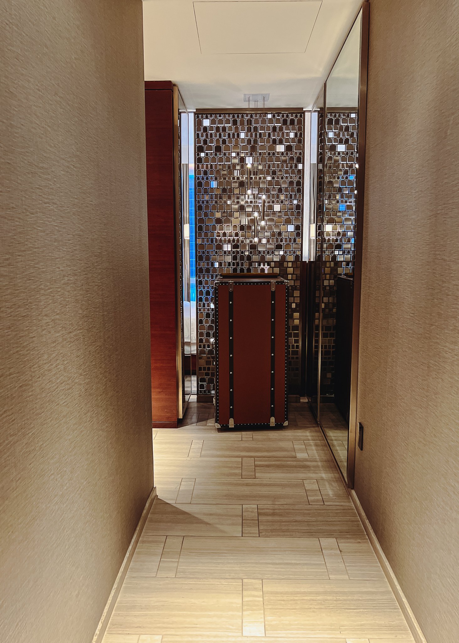 a hallway with a mirror wall and a brown box