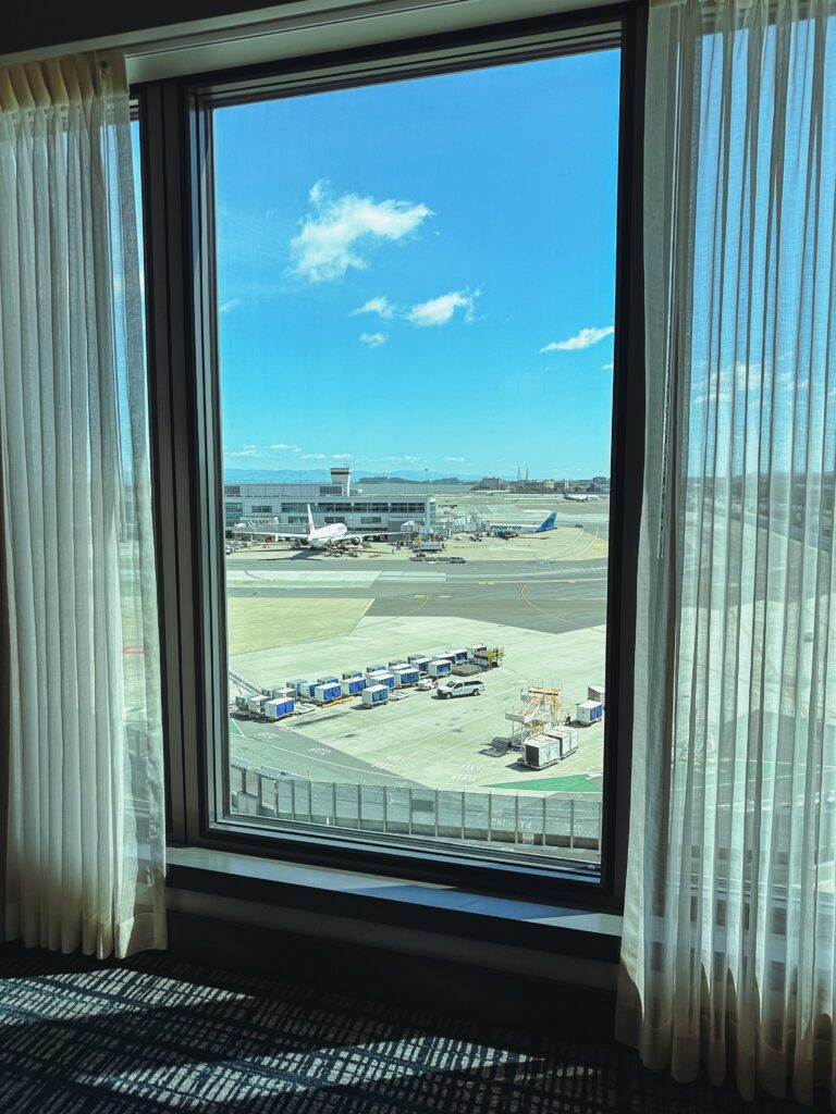 a window with a view of an airport and a runway