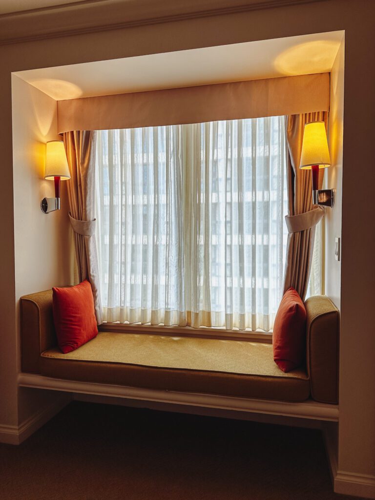 a window seat with pillows and lamps