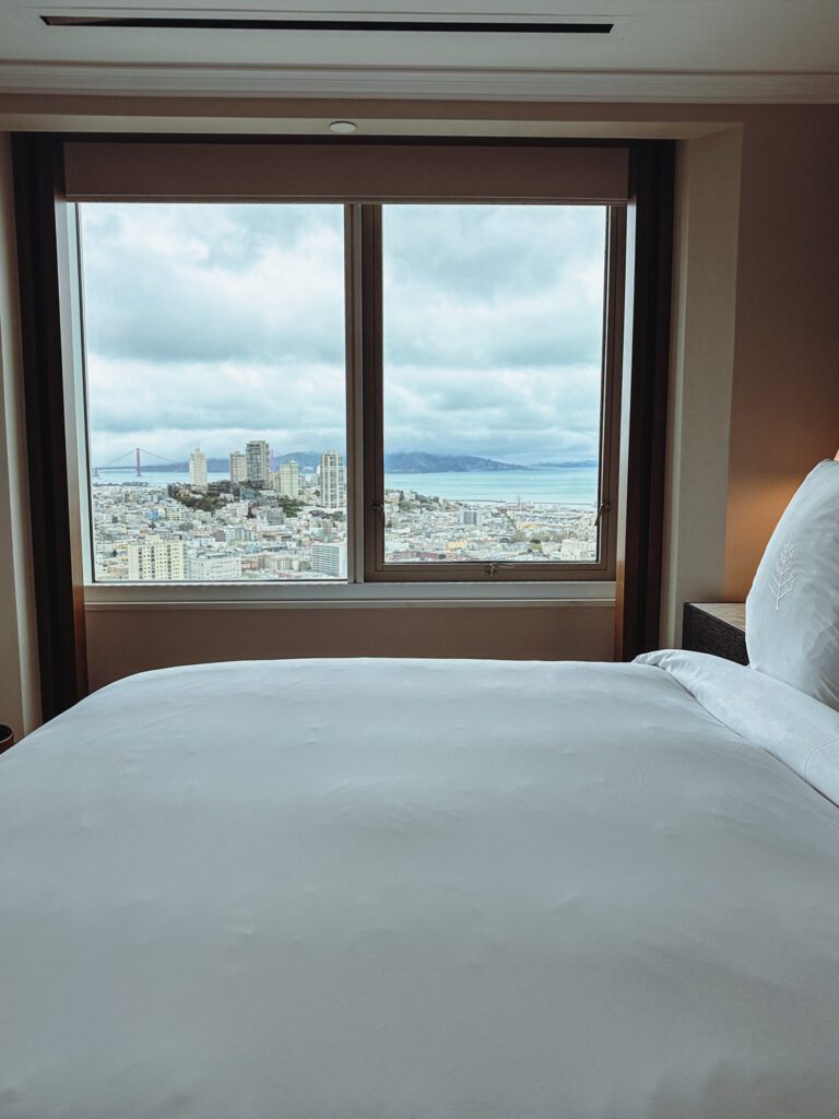 a bed with a view of a city and a bay