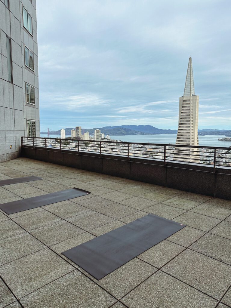 a rooftop with yoga mats and a city skyline
