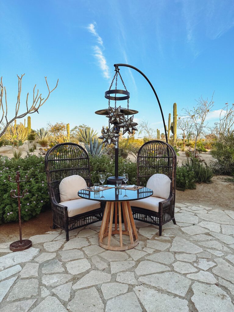 a table and chairs outside with a chandelier