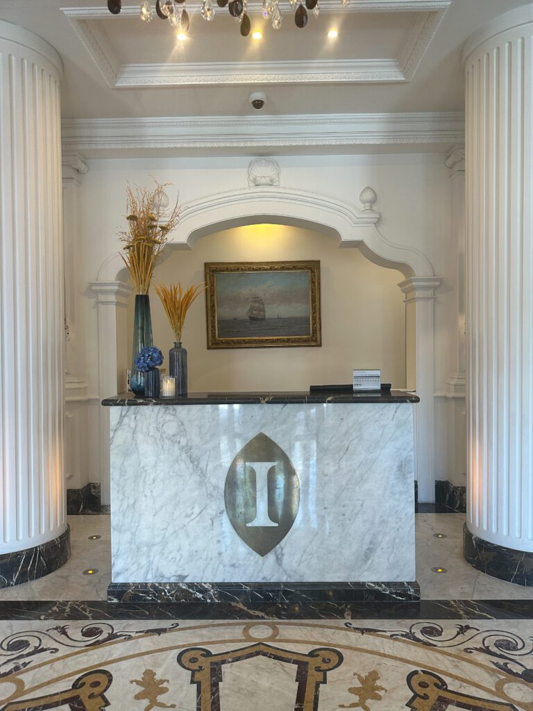 a marble reception desk with columns and a picture frame